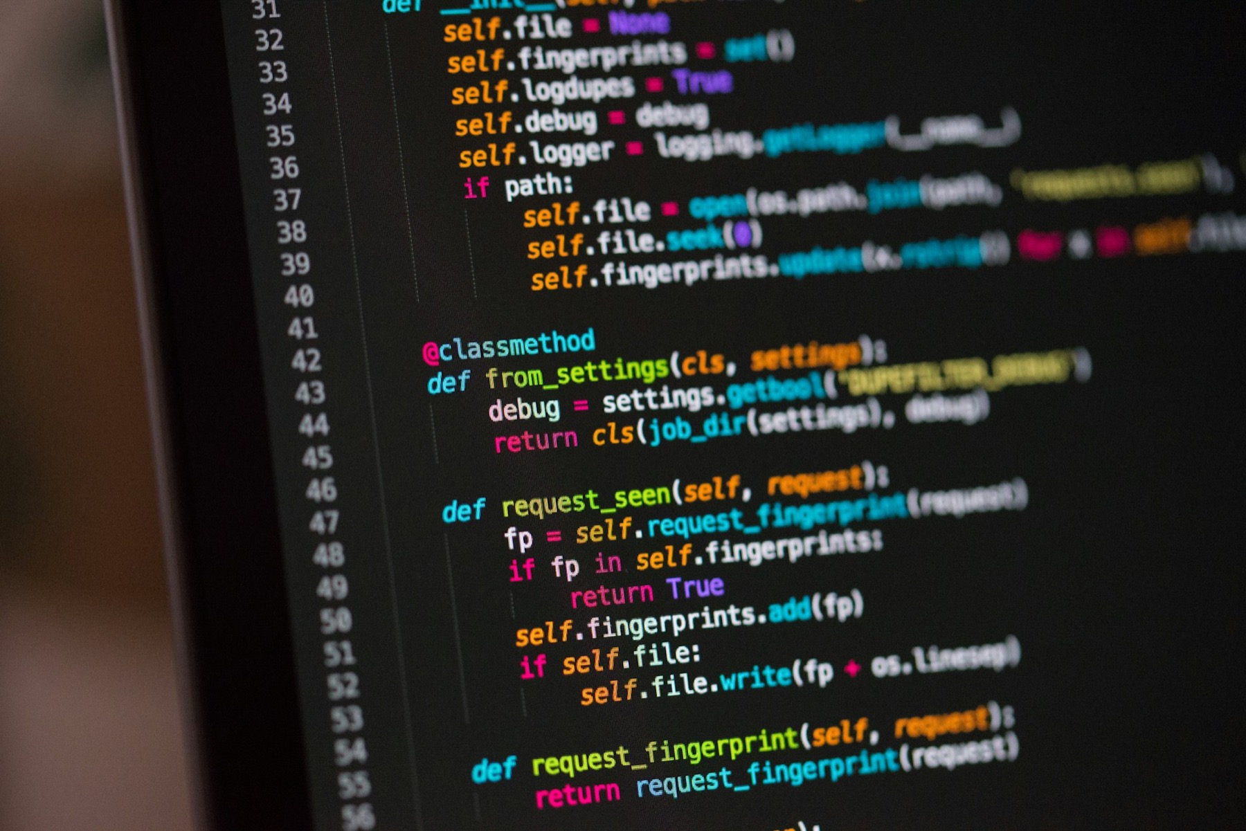 Close-up of colorful Python code with line numbers on a dark laptop screen