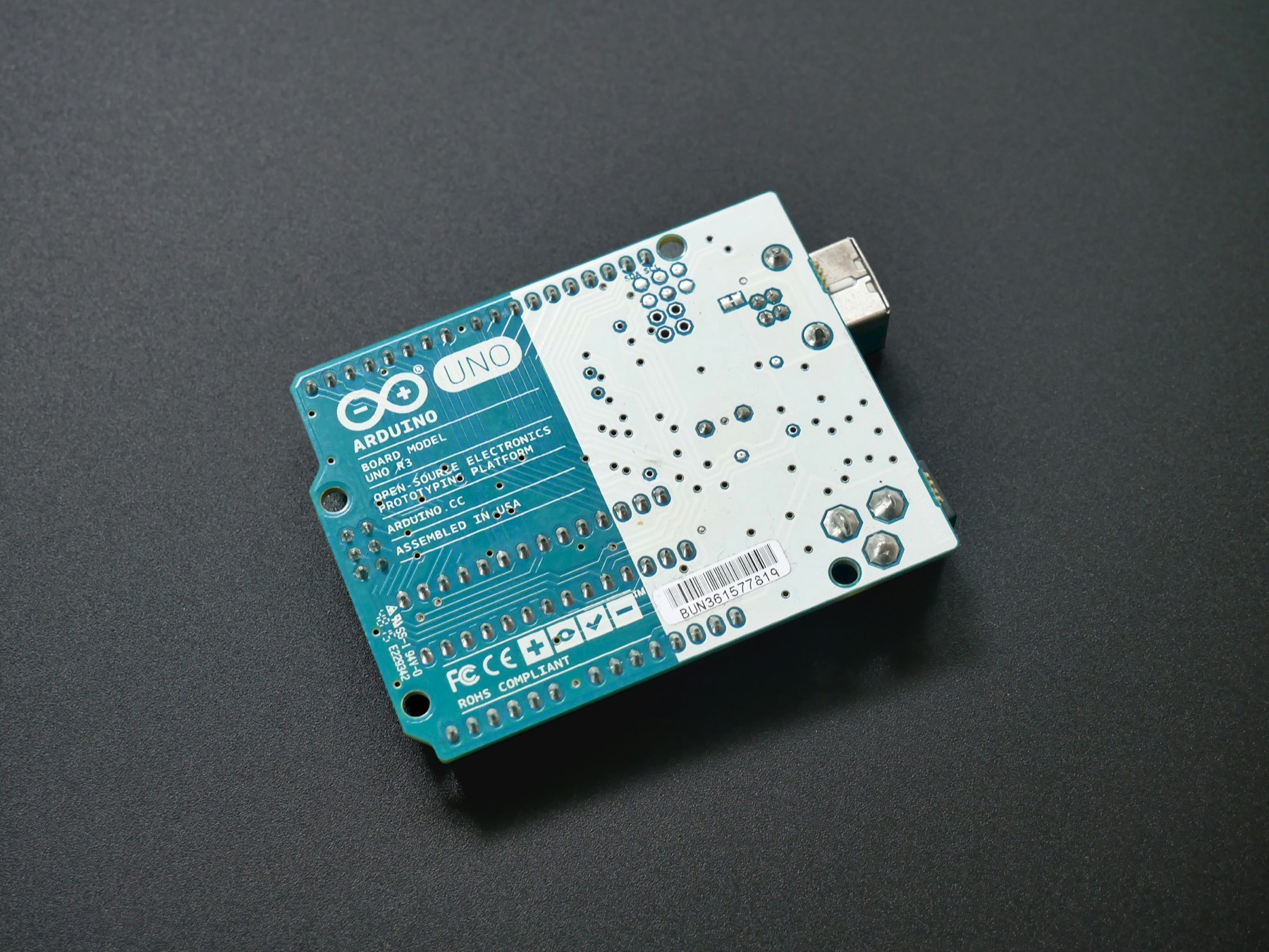 An Arduino Uno board on a dark desk